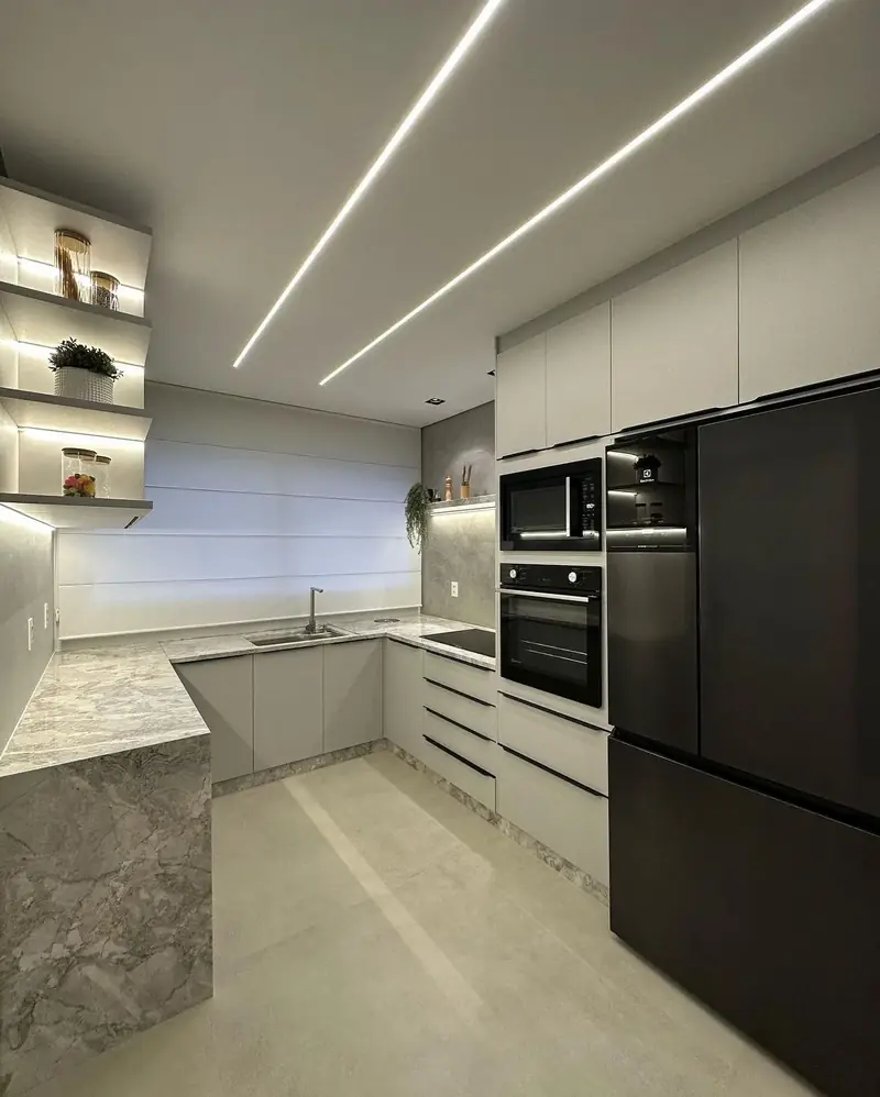 Cozinha planejada em tons de cinza com iluminação embutida
